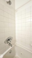Shower-over-tub combination with white textured wall tiling - 