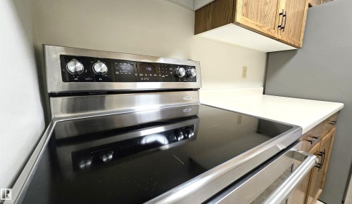 Stainless steel range featuring a sleek black cooktop, digital controls, and large knob hardware - 415 15503 106 Street, Edmonton, AB - Indoor Photo Showing Kitchen