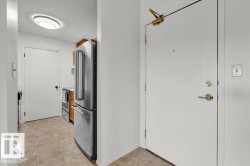 Entrance featuring a white panel door with brass hardware and an overhead door closer - 