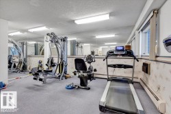 Carpeted fitness area with full-wall mirrors and multiple windows - 