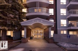 Building entrance featuring an awning, brick facade, and light-colored siding - 