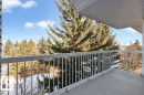 Spacious balcony featuring a gray concrete surface, light-colored metal railing, and a slatted ceiling overhead - 415 15503 106 Street, Edmonton, AB  - Outdoor 