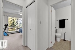 Bedroom featuring a full-width window with vertical blinds, ceiling fan, and light-colored carpet - 