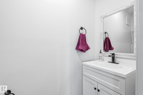 White vanity with an integrated sink, matte black faucet, and an ornate framed mirror - 23127 Twp Rd 502, Rural Leduc County, AB - Indoor Photo Showing Bathroom