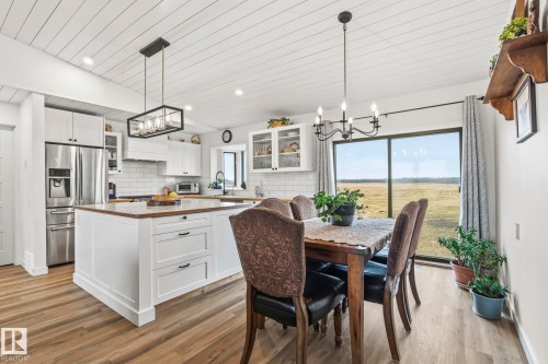 Open-concept kitchen and dining area featuring wood-finish flooring, a shiplap ceiling, and recessed lighting - 23127 Twp Rd 502, Rural Leduc County, AB - Indoor