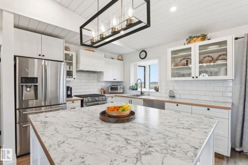 Kitchen island featuring a veined countertop - 23127 Twp Rd 502, Rural Leduc County, AB - Indoor Photo Showing Kitchen With Upgraded Kitchen