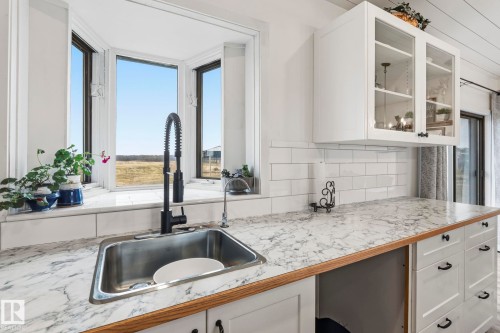 Kitchen sink with a matte black high-arc faucet, set against a bay window - 23127 Twp Rd 502, Rural Leduc County, AB - Indoor Photo Showing Kitchen