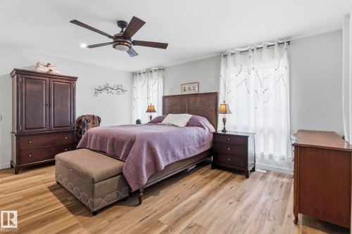 Spacious room featuring wood-finish flooring, light grey walls, and a ceiling fan with integrated lighting - 23127 Twp Rd 502, Rural Leduc County, AB - Indoor Photo Showing Bedroom