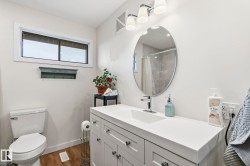 Bathroom featuring a white vanity with shaker-style cabinetry, a single basin sink, and a chrome faucet - 