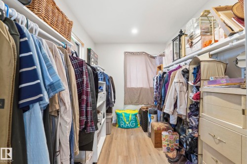 Walk-in closet featuring wood-finish flooring, recessed lighting, built-in shelving, and a window with privacy coverings - 23127 Twp Rd 502, Rural Leduc County, AB - Indoor With Storage