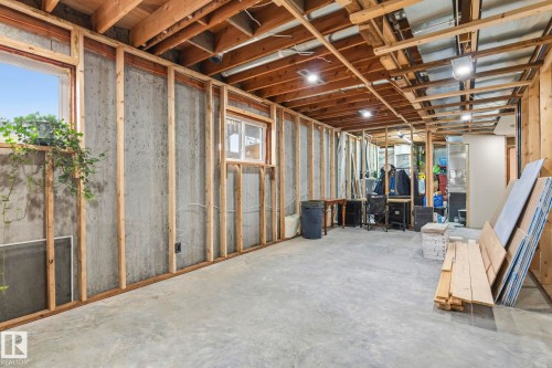 Expansive unfinished basement featuring concrete walls and flooring, wood framing, exposed wood ceiling joists, and multiple windows - 23127 Twp Rd 502, Rural Leduc County, AB - Indoor Photo Showing Basement