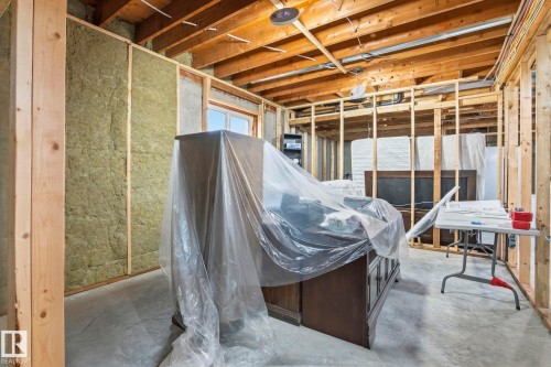 Unfinished interior space featuring exposed wooden framing, visible insulation within wall cavities, a window opening, concrete flooring, and exposed ceiling joists - 23127 Twp Rd 502, Rural Leduc County, AB - Indoor Photo Showing Basement