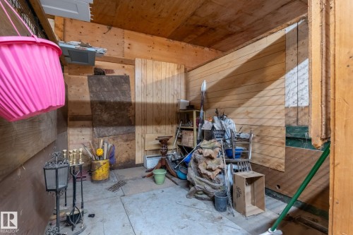 Utility space featuring wood paneling on walls and ceiling, a concrete floor, and built-in shelving - 23127 Twp Rd 502, Rural Leduc County, AB - Indoor