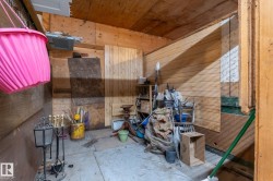Utility space featuring wood paneling on walls and ceiling, a concrete floor, and built-in shelving - 