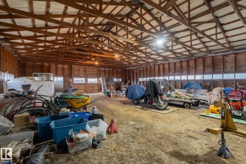 Spacious barn interior featuring exposed wood beams, a high vaulted ceiling, multiple windows, and overhead lighting - 23127 Twp Rd 502, Rural Leduc County, AB - Indoor Photo Showing Other Room