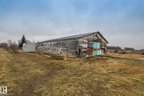 Outbuilding with a metal roof and painted wooden siding, set on a large, open lot - 23127 Twp Rd 502, Rural Leduc County, AB - Outdoor With View