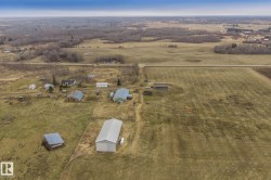 Expansive acreage featuring multiple outbuildings, including a large metal-roofed structure and several smaller sheds - 
