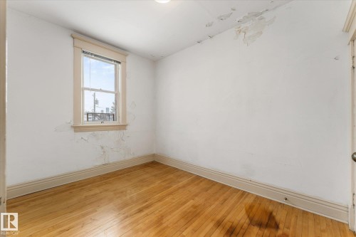 Hardwood flooring, natural light through a single window, white walls, and white trim - 10921 126 Street, Edmonton, AB - Indoor Photo Showing Other Room