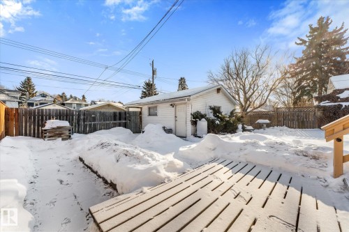 Expansive backyard featuring a wood-slat deck, a detached garage, and perimeter wood fencing - 10921 126 Street, Edmonton, AB - Outdoor