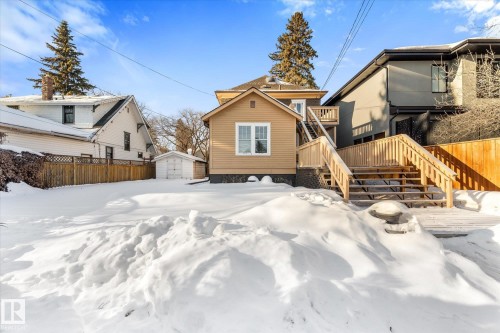 Expansive rear property featuring a multi-level wood deck with railing, a detached single-car garage, and a wood privacy fence - 10921 126 Street, Edmonton, AB - Outdoor