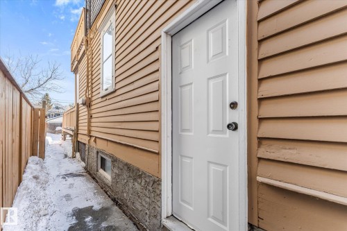 Side entry door with paneling, set against horizontal siding - 10921 126 Street, Edmonton, AB - Outdoor With Exterior