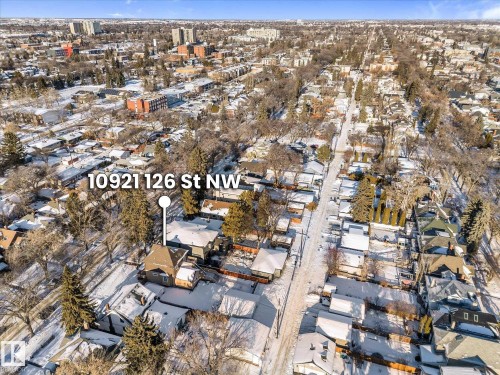 Single-family residence with a dark-toned gabled roof and light-colored siding, situated on a snow-covered lot - 10921 126 Street, Edmonton, AB - Outdoor With View
