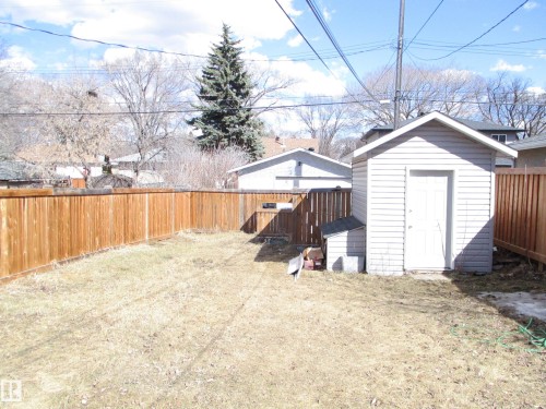 Expansive backyard with a full wood privacy fence and a detached storage shed - 12115 64 Street Nw, Edmonton, AB - Outdoor