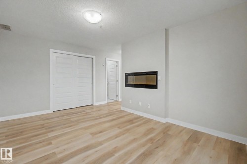 1225 5151 Windermere Boulevard, Edmonton, AB - Indoor Photo Showing Other Room With Fireplace