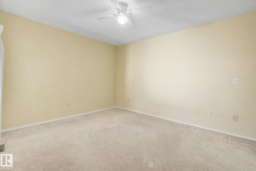 Carpeted room featuring a ceiling fan with integrated lighting, neutral wall tones, and white trim - 1542 54 Street, Edmonton, AB - Indoor Photo Showing Other Room