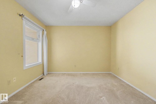 Bright room with beige carpeting, light yellow walls, and white trim - 1542 54 Street, Edmonton, AB - Indoor Photo Showing Other Room