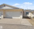 Stucco exterior featuring multiple garage doors, a concrete driveway, and a shingled roof - 1542 54 Street, Edmonton, AB  - Outdoor 