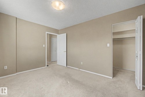 Carpeted room with neutral-toned walls, white trim, and a flush mount ceiling light fixture - 1542 54 Street, Edmonton, AB - Indoor Photo Showing Other Room
