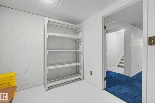 Open storage area featuring a white-painted concrete foundation wall, white painted concrete floor, and white drop ceiling - 1542 54 Street, Edmonton, AB - Indoor