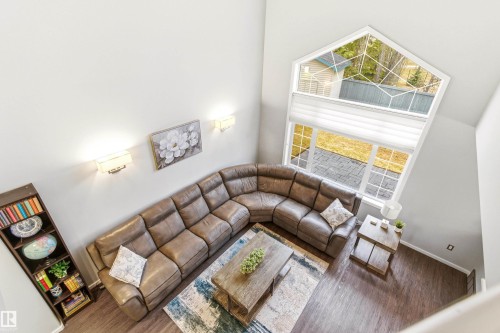 Vaulted ceiling great room featuring a prominent architectural window, wood-finish flooring, and recessed lighting - 14755 131 Street Nw, Edmonton, AB - Indoor