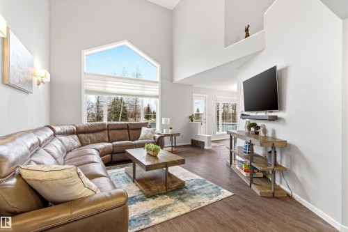 Vaulted ceilings complement the large picture windows with an angular transom, enhancing the open concept living area - 14755 131 Street Nw, Edmonton, AB - Indoor Photo Showing Living Room
