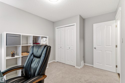 Carpeted room with light gray walls, a white bi-fold closet, and a white interior door - 14755 131 Street Nw, Edmonton, AB - Indoor