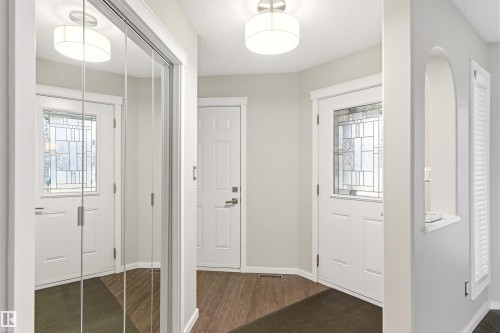 Entryway featuring wood-finish flooring and two white paneled doors - 14755 131 Street Nw, Edmonton, AB - Indoor Photo Showing Other Room