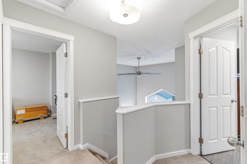 Upper-level landing featuring light gray walls, white trim, and neutral carpet - 14755 131 Street Nw, Edmonton, AB - Indoor Photo Showing Other Room