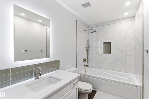 Modern bathroom featuring a back-lit mirror, integrated sink, and white subway tile backsplash - 14755 131 Street Nw, Edmonton, AB - Indoor Photo Showing Bathroom