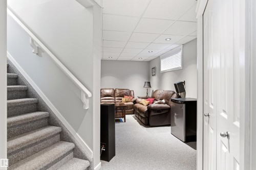 Carpeted staircase with white handrail leading to a finished lower level - 14755 131 Street Nw, Edmonton, AB - Indoor Photo Showing Other Room