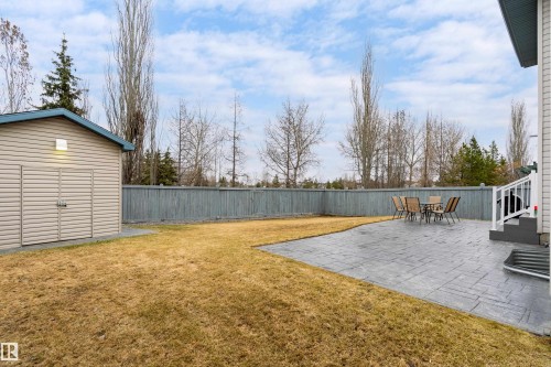 Expansive backyard featuring a patterned concrete patio, a detached storage shed, and a privacy fence - 14755 131 Street Nw, Edmonton, AB - Outdoor