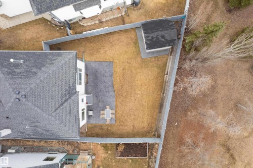 Expansive backyard featuring a paver patio with a dining area, a separate storage shed with a shingle roof, and a perimeter fence - 14755 131 Street Nw, Edmonton, AB - Outdoor