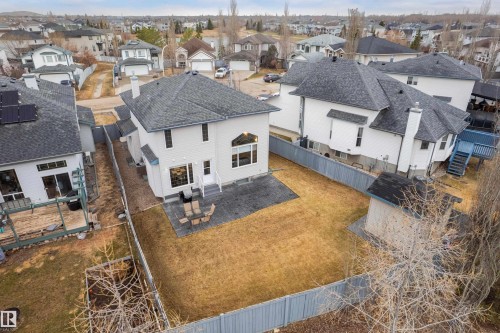 Spacious fenced backyard featuring a paved patio area, detached shed, and mature perimeter trees - 14755 131 Street Nw, Edmonton, AB - Outdoor With View