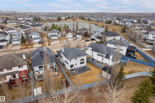 White two-story residence featuring a dark shingle roof, a rear patio with outdoor seating, and a private fenced backyard with a shed - 14755 131 Street Nw, Edmonton, AB - Outdoor With View