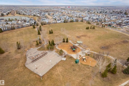 Expansive park grounds featuring a basketball court, multiple play structures, covered gazebo, walking paths, and open fields with soccer goals - 14755 131 Street Nw, Edmonton, AB - Outdoor With View