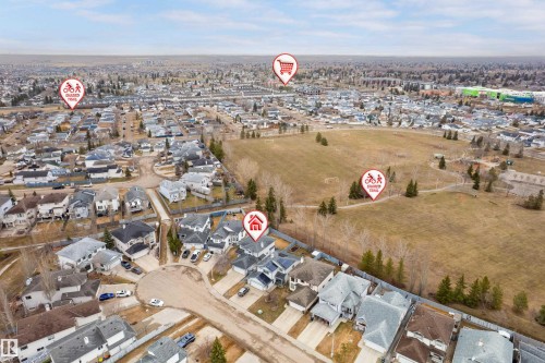 Aerial view of a residential neighborhood with numerous single-family homes, a large open field, and several paved pathways - 14755 131 Street Nw, Edmonton, AB - Outdoor With View
