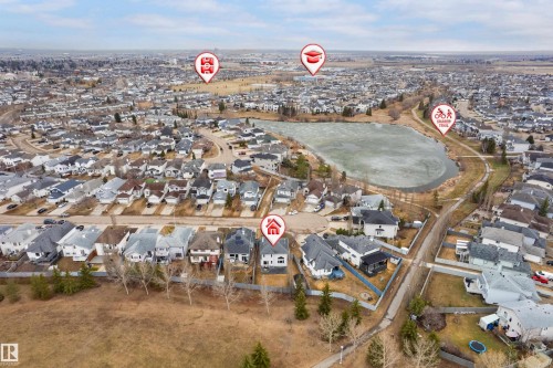Aerial perspective showcasing a residential area with a prominent pond feature and surrounding green spaces - 14755 131 Street Nw, Edmonton, AB - Outdoor With View