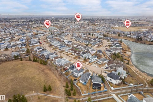 Aerial view of a residential neighborhood with numerous single-family homes, a river with a frozen surface, and open fields - 14755 131 Street Nw, Edmonton, AB - Outdoor With View