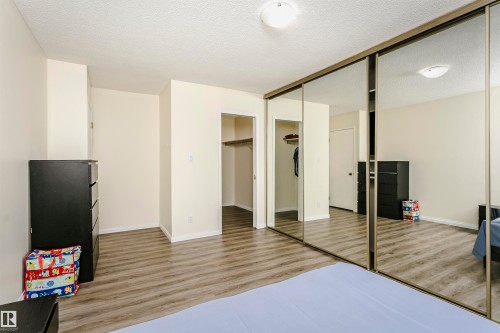 Room featuring wood-finish flooring, light-toned wall paint, and overhead flush-mount lighting - 303 10026 112 Street, Edmonton, AB - Indoor