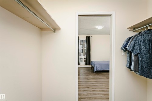 Closet with built-in shelving and clothing rods - 303 10026 112 Street, Edmonton, AB - Indoor Photo Showing Other Room